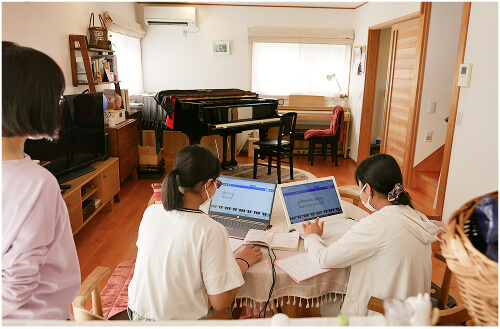 パソコンで音楽を作る女子2人の写真