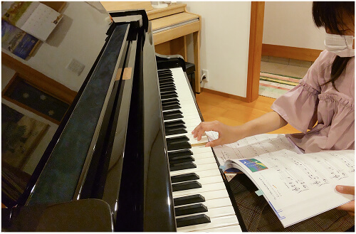 楽譜を見ながら音を確認する女の子